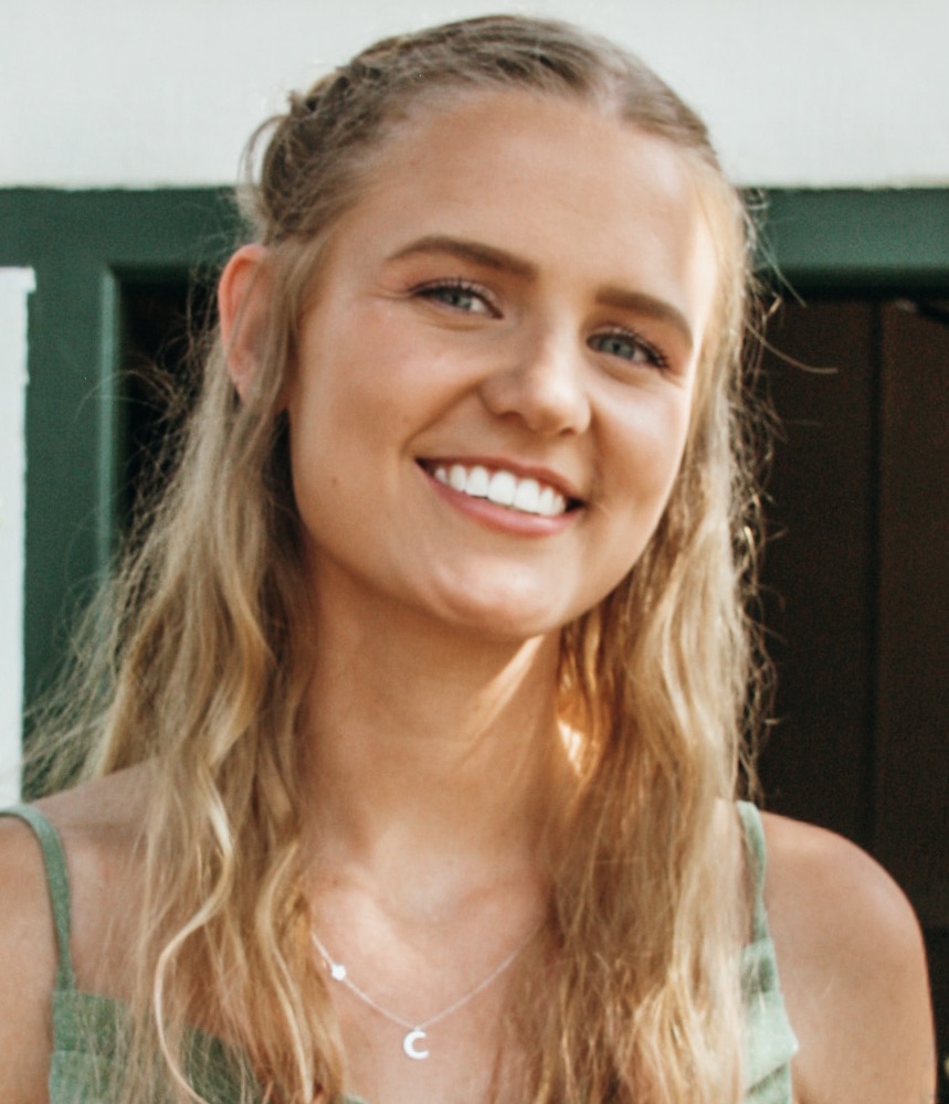 A person smiling at the camera Description automatically generated